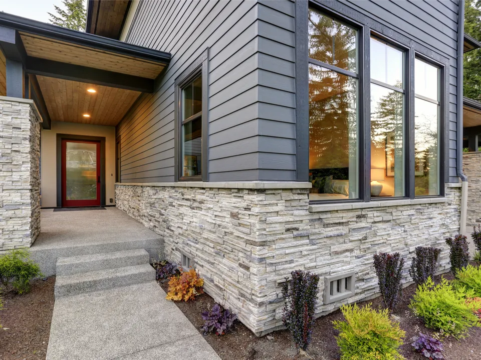Home with new siding, stone accent, and trim by Vista Home Improvement